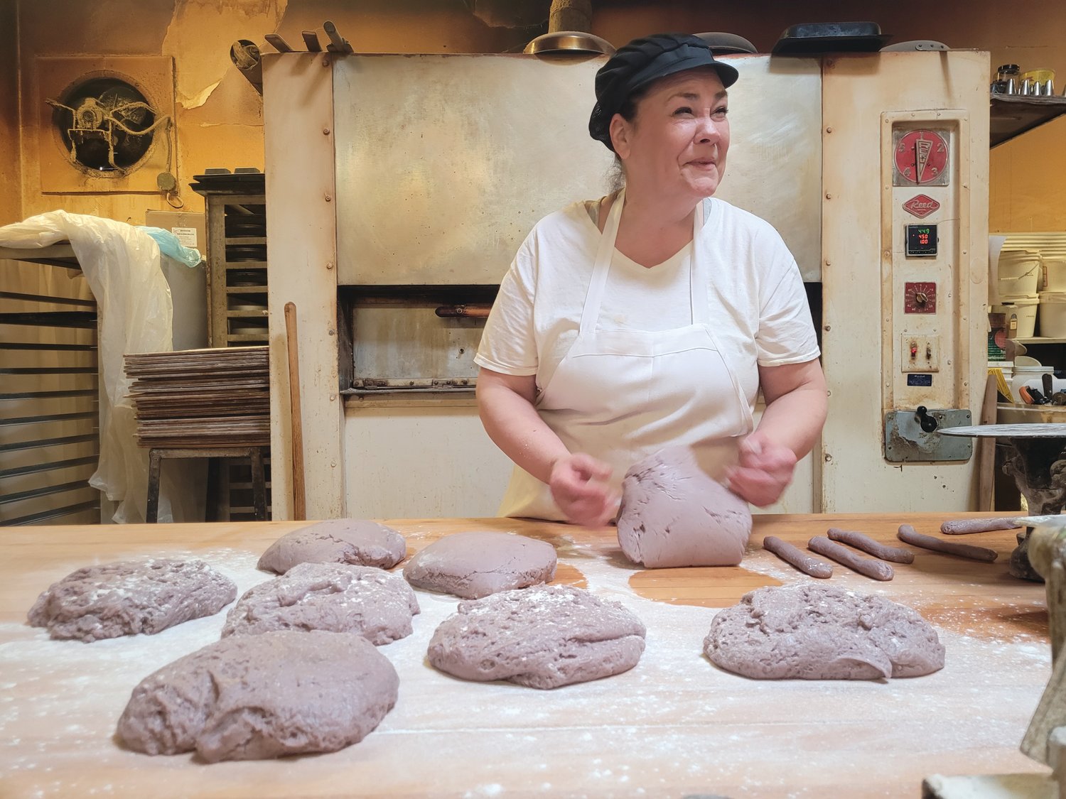 WINE, DON’T WHINE: Elena Pennacchini stood in the back of her family bakery, Solitro’s, rolling purple piles of dough into small circular twisted wine biscuits.